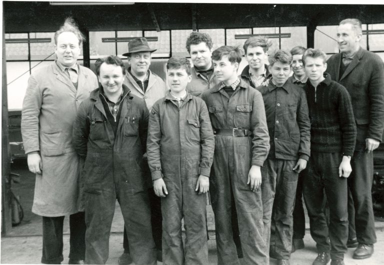 Historisches Foto der Belegschaft in Arbeitskleidung