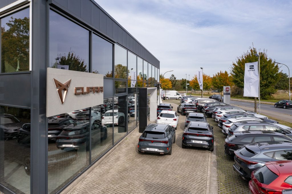 Außenansicht des Autohauses Brüning mit Fahrzeugen auf dem Hof